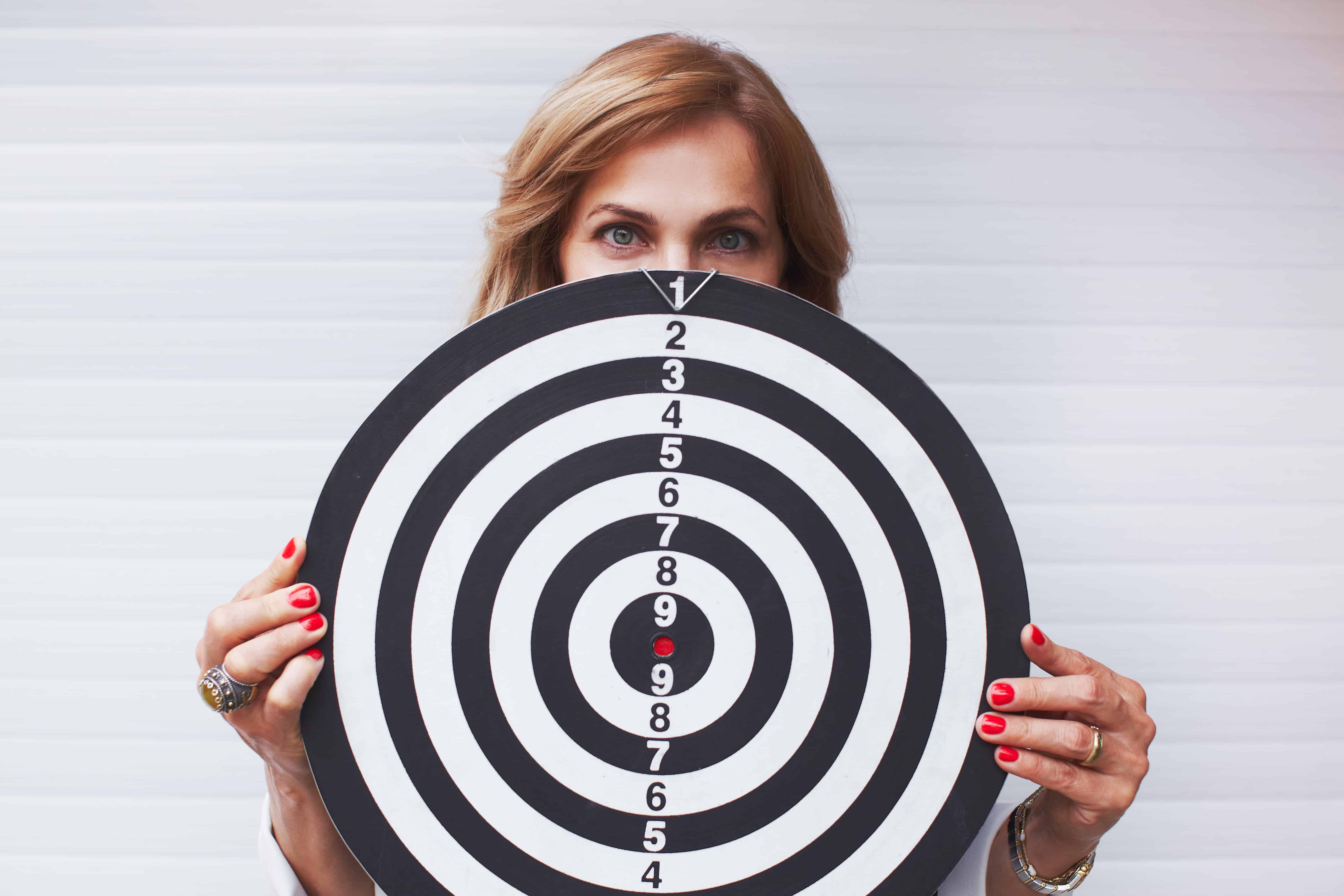A women holding a dart target board.