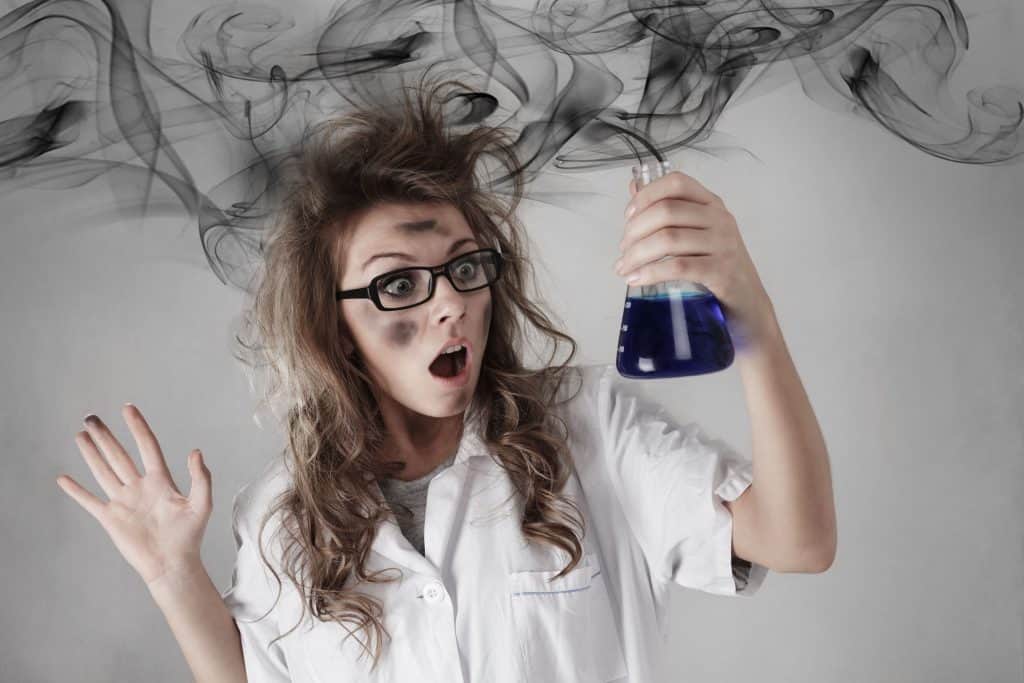 A woman holding a cylinder looking scared inside science laboratory.