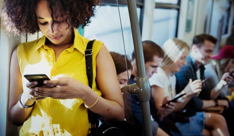 A woman inside the train texting on her phone.